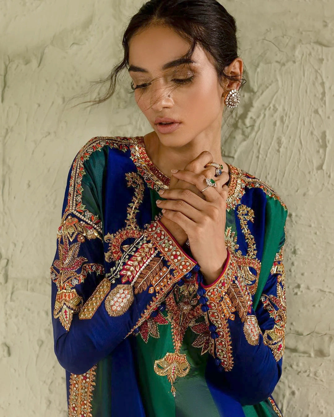 Woman wearing a traditional embroidered outfit with a neutral background