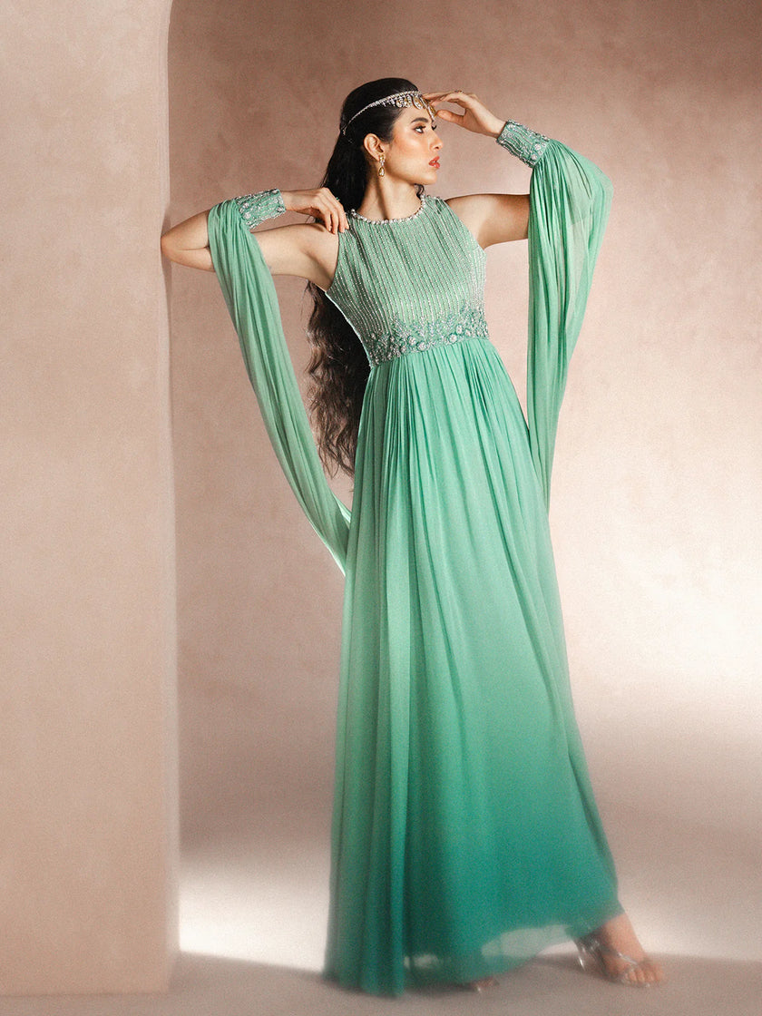 Woman wearing a green evening gown with a plain background